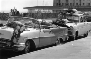 Holiday makers in Clacton-on-Sea relax in the heat by lying on top of their parked cars. (Photo by Evening Standard/Getty Images). 31st July 1967