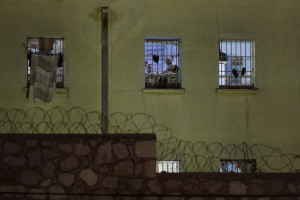 Inmates are seen in the Korydallos Prison on Sunday, May 3, 2015, after two prisoners died, both of Pakistani nationality, and 21 others were injured in a brawl among inmates Sunday, authorities say.  All injured people, some in serious condition, have been taken to outside hospitals for treatment. (AP Photo/Petros Giannakouris)