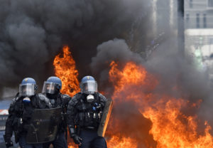 French riot police stand next to a fire as they take a position after clashes erupted on March 24, 2016 in Nantes, western France, during a demonstration against the French government's proposed labour reforms. Students protesting labour reforms took to the streets across France on March 24, torching cars in Paris and clashing with riot police who responded with tear gas and made about two dozen arrests. Fifteen protesters were arrested in Paris, where two policemen were injured, and another nine students were detained in the western city of Nantes.  / AFP / LOIC VENANCE        (Photo credit should read LOIC VENANCE/AFP/Getty Images)